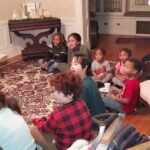 children sitting on floor listening to the christmas stories