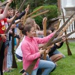 photo of kneeling students holding imitation wooden civil war rifles
