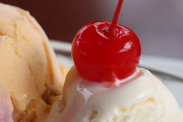 photo of ice cream with red cherry on top