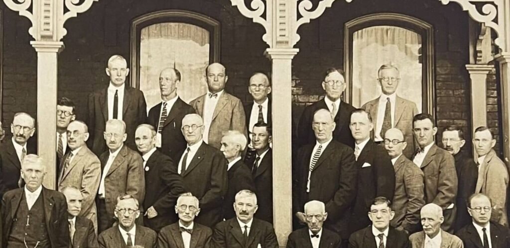 we need your help to identify this image of a multi row group of men in business suits standing in front of a building in lawrence county pennsylvania