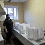 Farone Catering employee preparing take out meal boxes